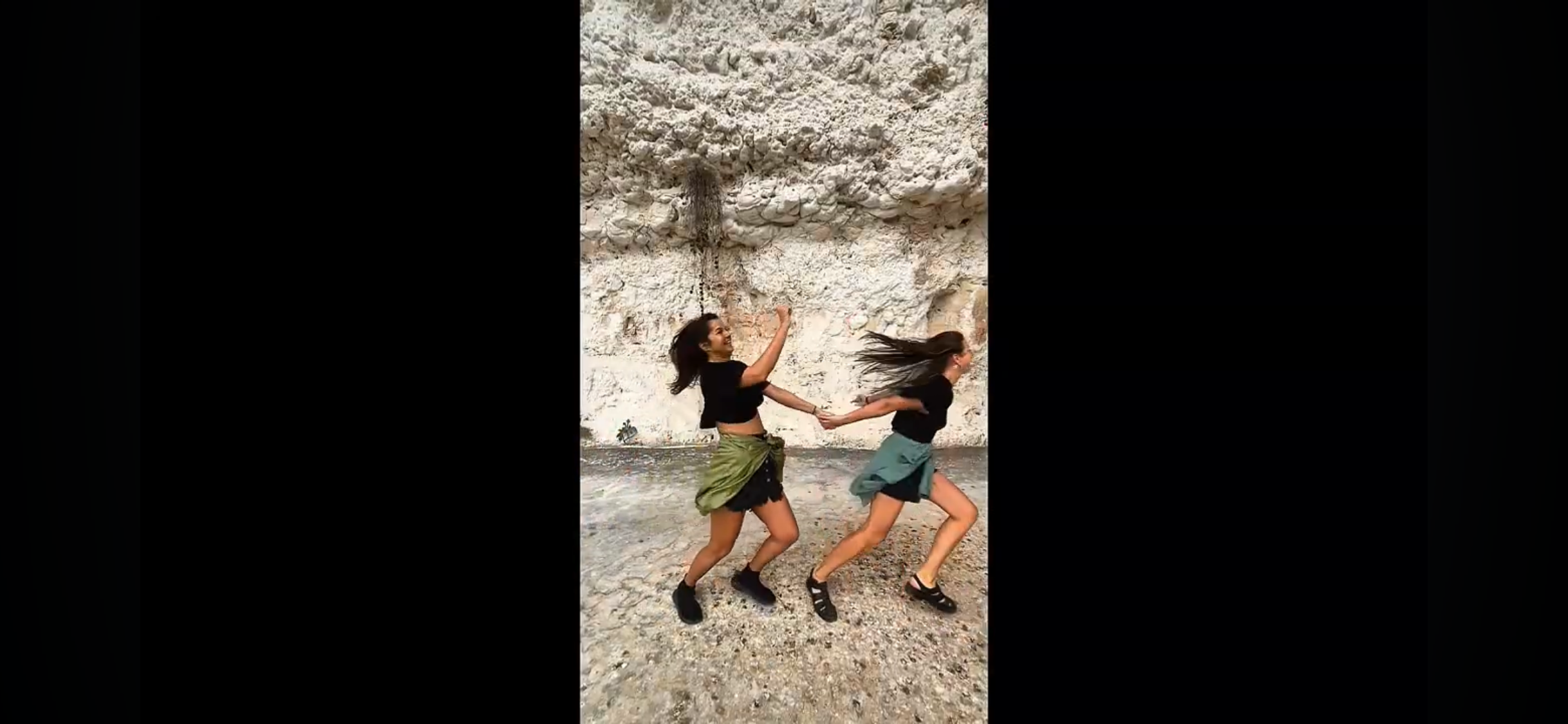 Load video: A person pulls their friend in and out of the frame at different locations on a trip.